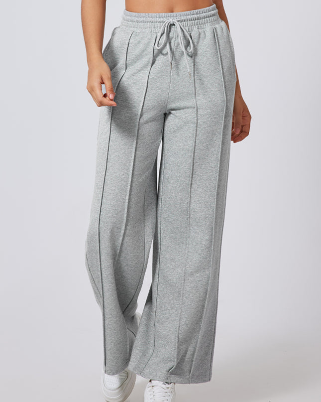 Person wearing gray wide-leg pants on a plain background