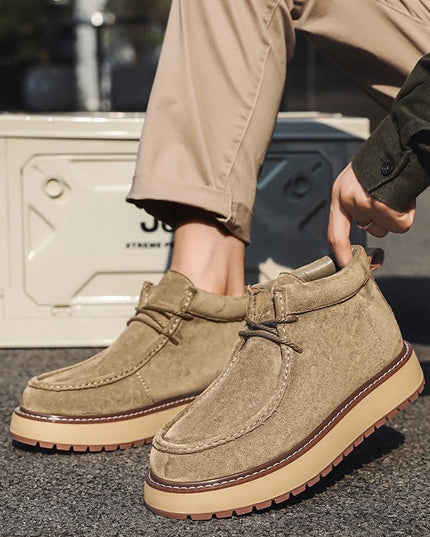 Brown suede shoes worn with beige pants on a dark surface