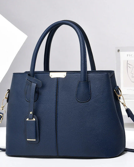 Blue handbag with gold accents on a white background