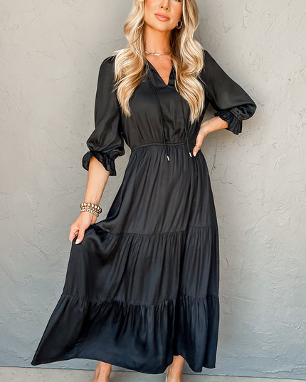 Woman wearing a black dress against a gray background