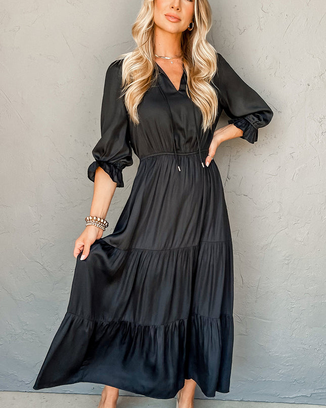 Woman wearing a black dress against a gray background