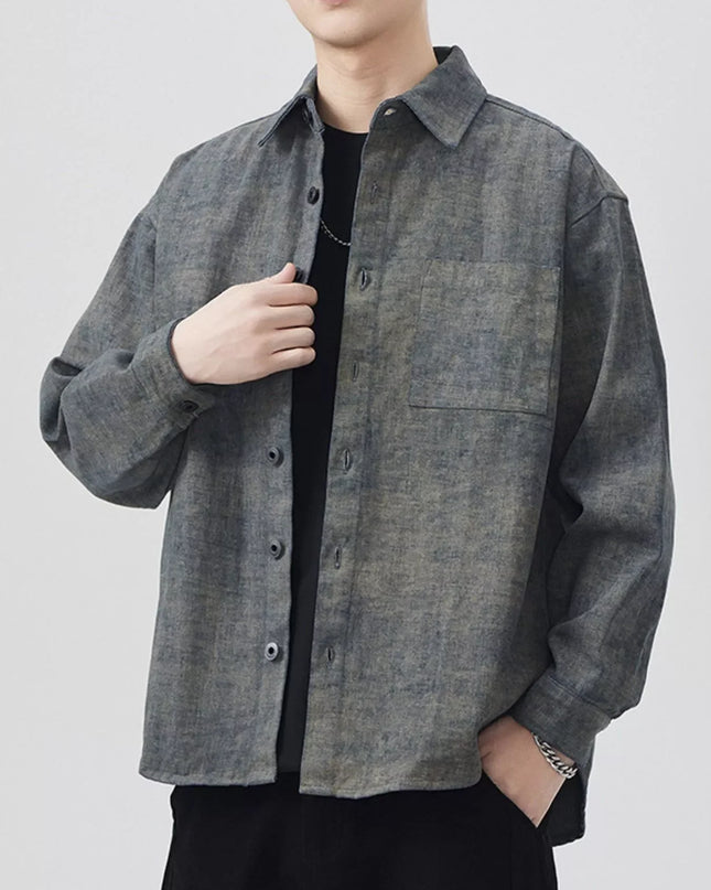 Person wearing a gray checkered shirt over a black shirt on a white background