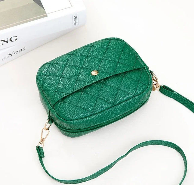 Green quilted handbag with a strap on a white background