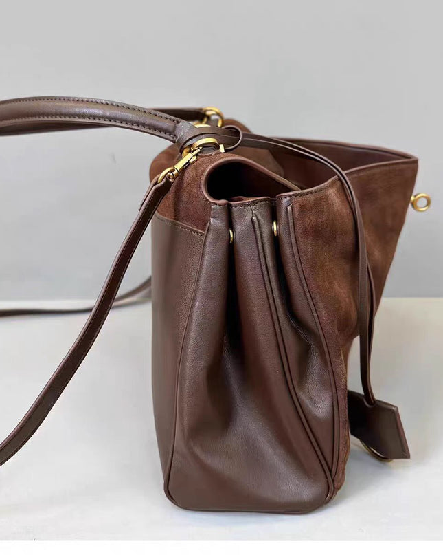 Brown leather handbag with a strap on a light gray background