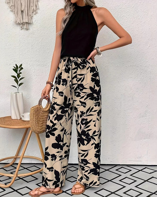 Woman wearing black floral pants and a black top in a minimalistic room.