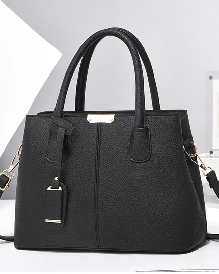 Black handbag with gold accents on a white background