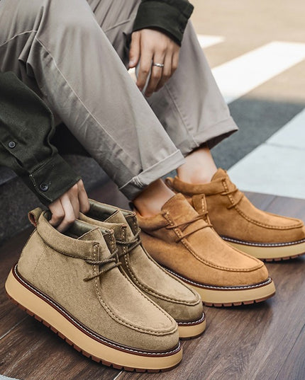 Two pairs of brown suede shoes on a wooden floor.