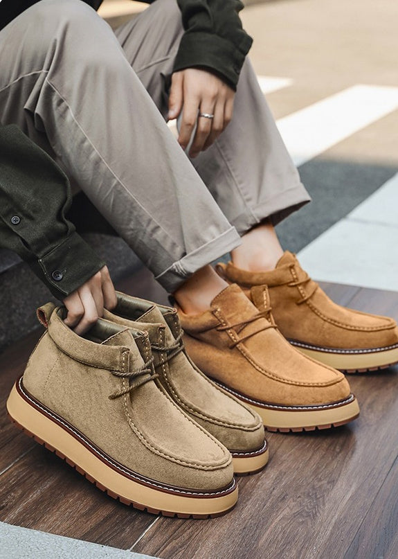 Two pairs of brown suede shoes on a wooden floor.