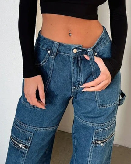 Person wearing blue jeans and a black long-sleeve top against a plain background