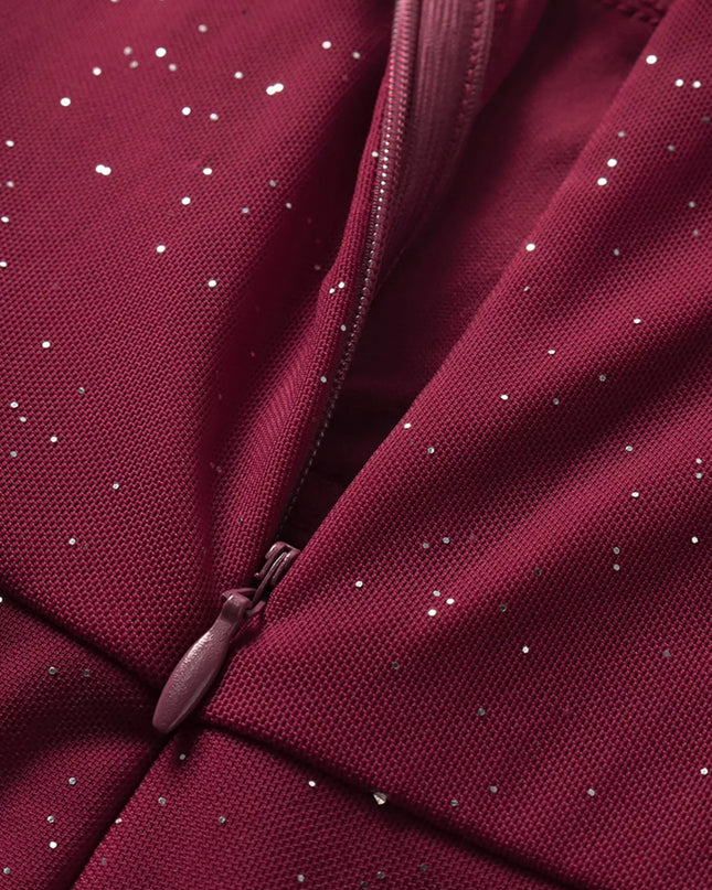 Close-up of a maroon fabric with a zipper and small white specks.