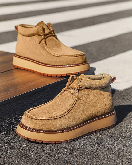 Pair of tan suede boots on a crosswalk