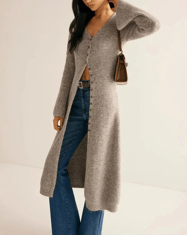 Woman wearing a long gray cardigan and blue jeans on a plain background