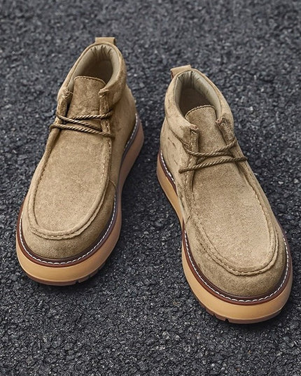 Pair of tan suede shoes on a dark textured surface