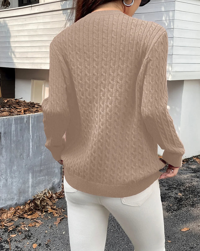 Person wearing a beige sweater and white pants standing outdoors.