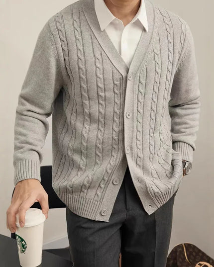 Person wearing a gray cable knit cardigan holding a Starbucks cup.