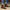 Brown ankle boots worn with blue jeans on a textured surface