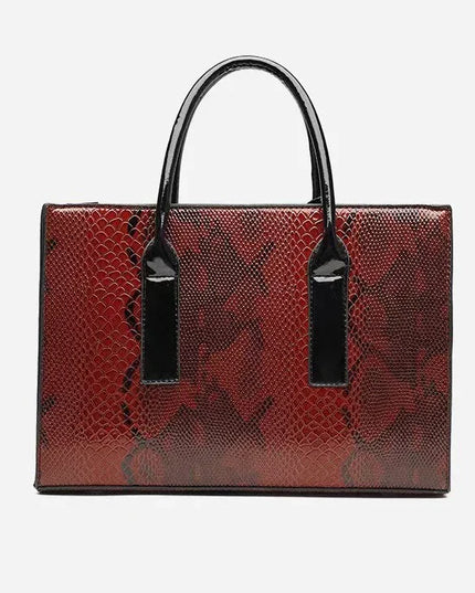 Red textured handbag with black handles and tags on a light gray background