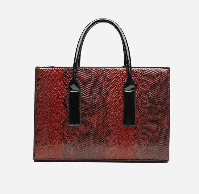 Red textured handbag with black handles and tags on a light gray background