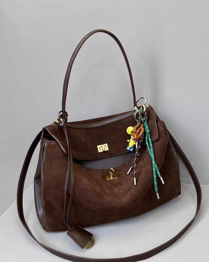 Brown leather handbag with keychain on a light gray background
